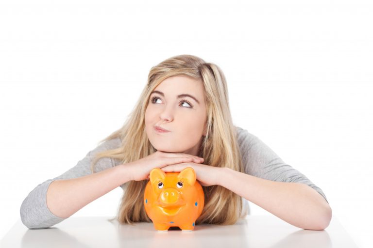 girl with her chin on a piggy bank