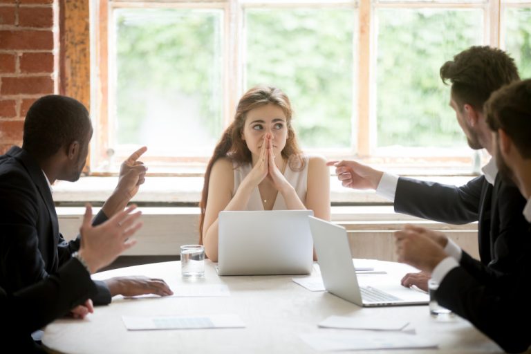 business people pointing fingers at businesswoman